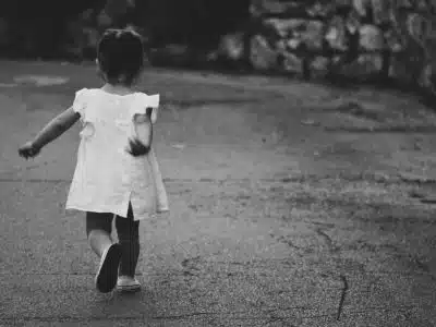 gray scale photography of girl walking towards destination