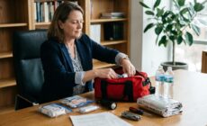 Femme d'affaires vérifiant un kit de secours organisé